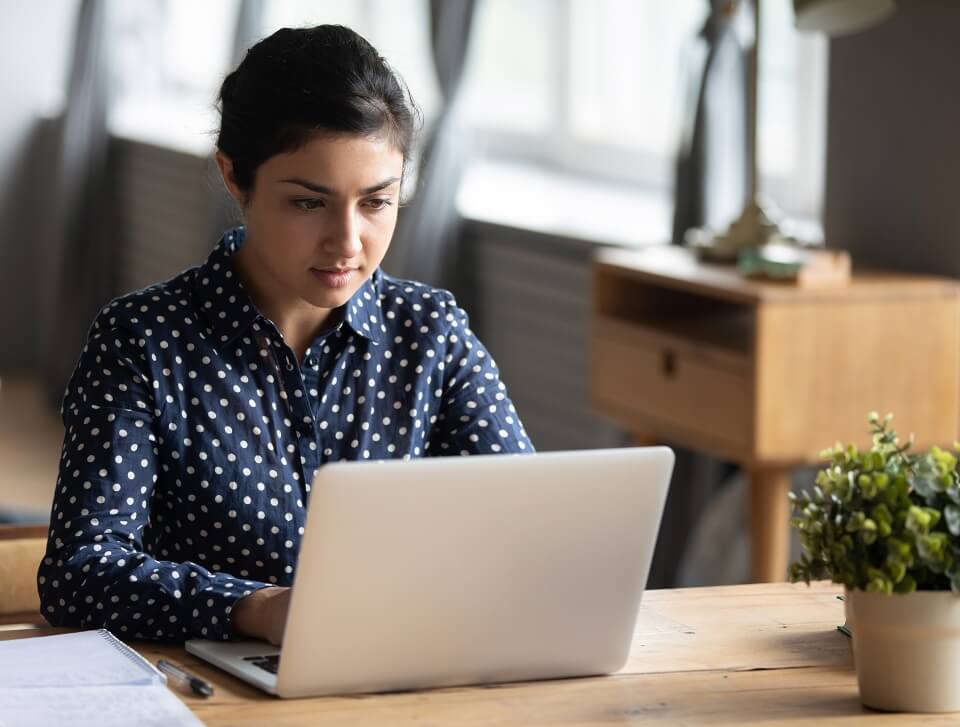 En kvinde foran en bærbar computer