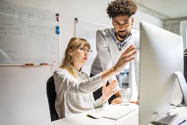 to personer, der ser på en computerskærm