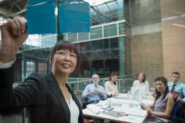woman pointing at notes with people watching